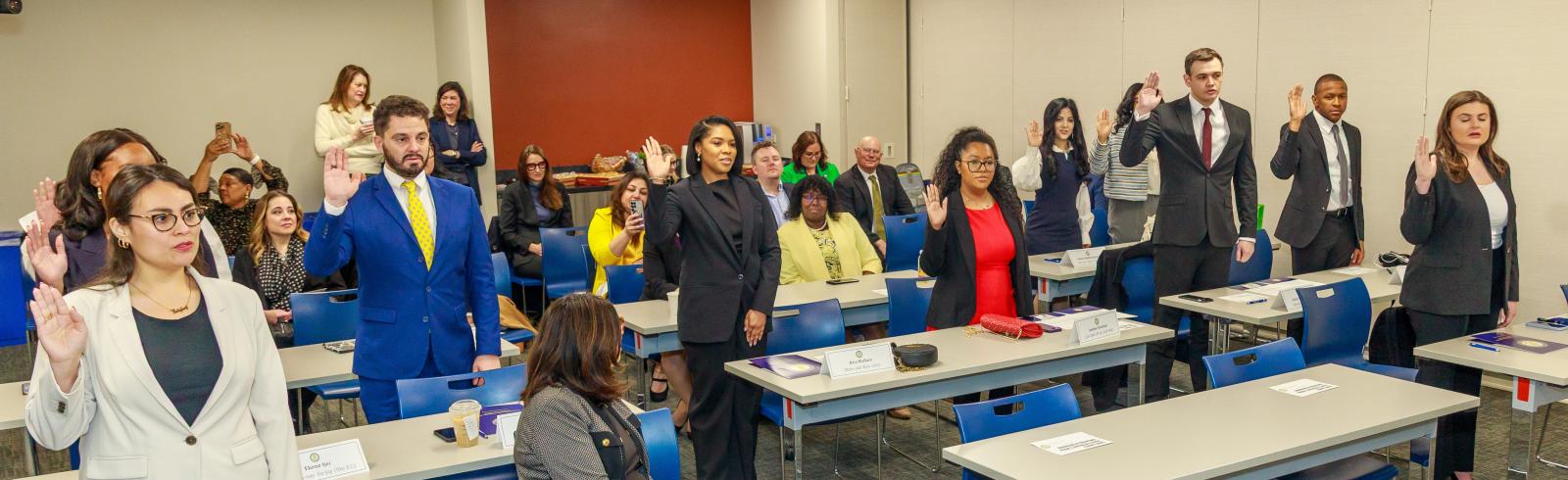 A group of Assistant States Attorneys raise their right hand and take the oath of office.